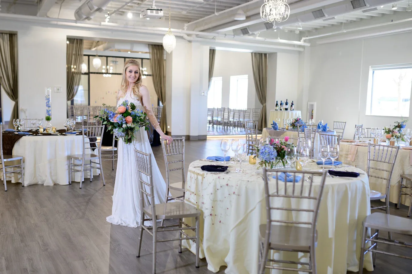 A bride holding a bouquet in a reception arrangement inside The Sterling Room
